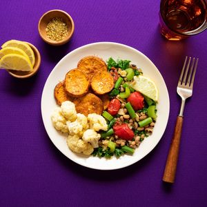 a plate of cauliflower, sweet potato and mixed greens with chickpeas