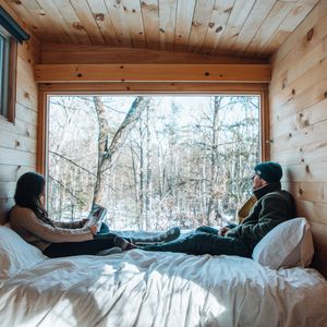 couple sitting on bed in getaway cabin