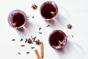 mulled wine with cinnamon sticks on white table