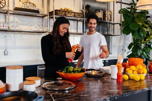 Man and woman cooking food in kitchen with Brandless household items