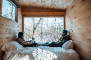 couple sitting on bed in getaway cabin